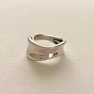 Detailed view of an irregular wavy minimalist 925 sterling silver open ring on white paper