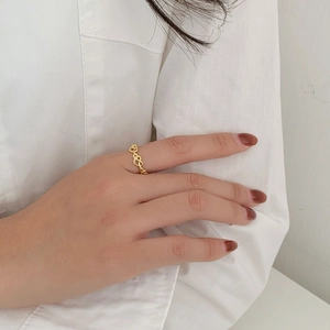 Detail of gold minimalist hollow heart chain ring worn on finger for casual style
