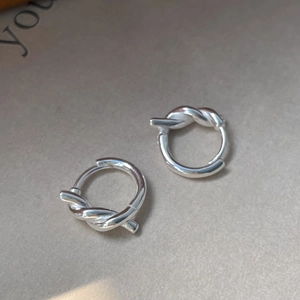 Vue détaillée de créoles en argent fin S925 avec design de nœud torsadé et finition polie