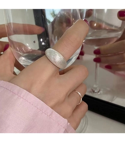 Close-up of minimalist brushed silver ring set on finger with elegant matte metal texture