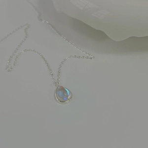 Detail of water drop silver necklace with blue moonstone pendant on white background