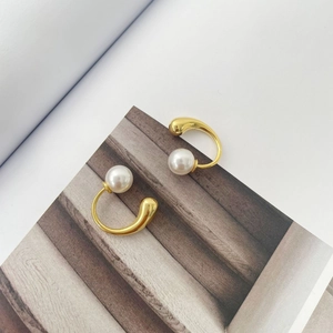 Close-up of S925 sterling silver mark on gold waterdrop earrings with white pearls