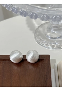 Macro detail of silver S925 sterling silver ball earrings with brushed matte texture finish