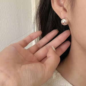 Macro detail of a minimalist 925 silver semi-circle stud earring on a model ear