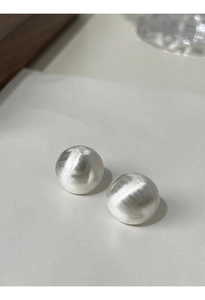 Macro detail of silver S925 sterling silver sphere earrings with brushed matte finish