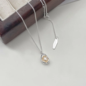 Detailed macro view of 925 sterling silver pea necklace with organic pearl pendant