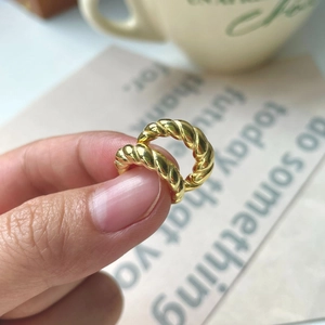 Minimalist twisted gold hoop earrings with polished texture in a lifestyle setting