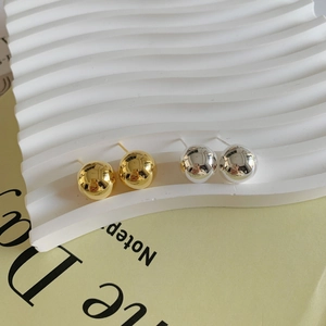 Minimalist silver and gold semi-circular stud earrings with polished mirror finish texture