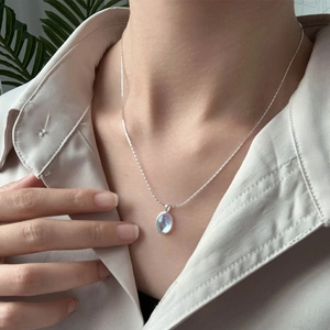 Close-up of S925 silver necklace with oval moonstone on model neck for elegant look