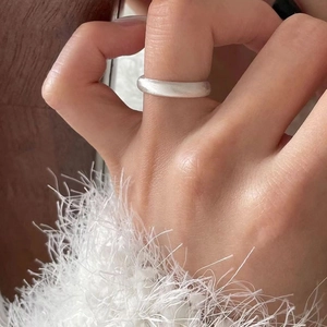 Macro shot of a minimalist matte 925 sterling silver ring on finger with soft texture