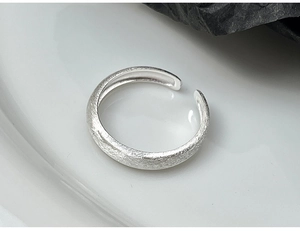 Macro detail of minimalist 925 sterling silver ring with brushed matte finish texture