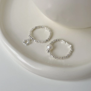 925 sterling silver beaded ring set with white pearl and floral charm on ceramic tray