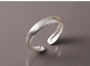 Macro shot of brushed 925 sterling silver ring showing matte texture and open band design