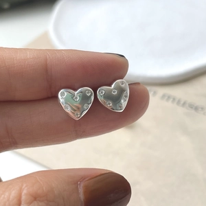 Close-up of sparkling heart-shaped S925 silver stud earrings with cubic zirconia inlay