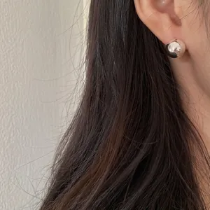 Minimalist 925 sterling silver ball stud earring shown on model in a soft macro view