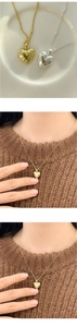 Detail of heart pendant necklace with cubic zirconia stars on a beaded chain