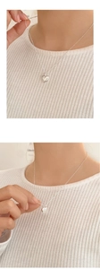 Detail of S925 sterling silver heart pendant necklace with stylish ball chain on model