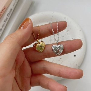 Detailed close-up of gold and silver heart pendants with sparkling cubic zirconia inlay