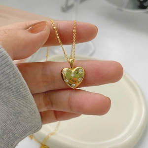 Detail of gold heart pendant with star-set cubic zirconia on a beaded satellite chain