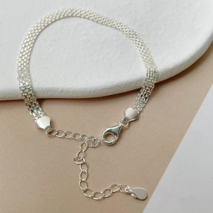 Détail macro du bracelet en maille argent S925 montrant le poinçon 925 et le fermoir