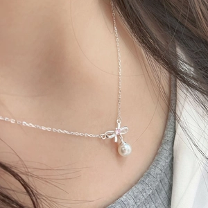 Detailed view of S925 silver bow necklace with pink zircon and white pearl on neck