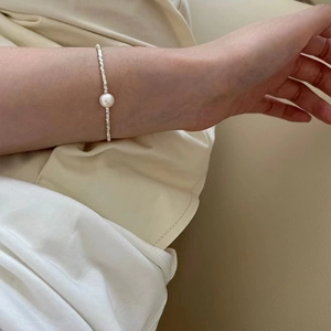Dettaglio del bracciale di perle in argento S925 con perla centrale sul polso donna