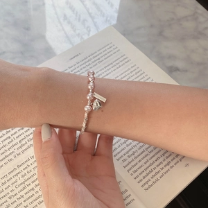Bracelet perles en argent sterling S925 avec cœur et perles roses sur fond de livre ouvert