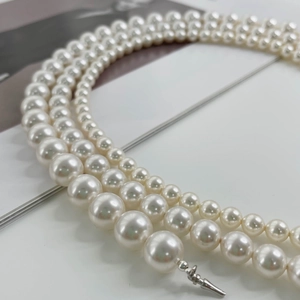Detailed view of triple-layered gradient pearl necklace with silver tapered clasp