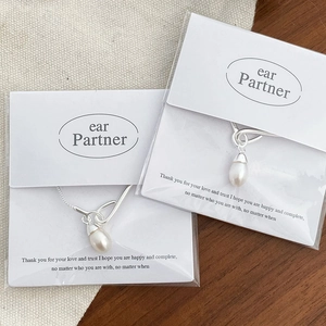 Macro shot of silver waterdrop pearl necklace on elegant card packaging