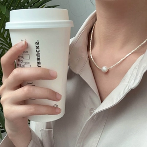 Elegante collana di perle in argento S925 indossata con una camicia beige