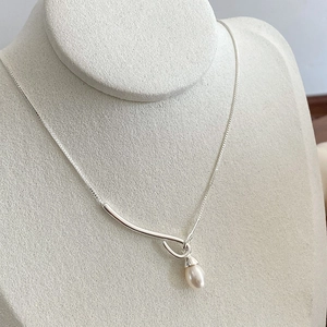 Detailed close-up of 925 sterling silver bar pendant with a pearl drop on a neck mannequin