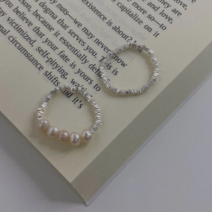 Minimalist S925 silver textured ring and elegant pearl ring set on vintage book pages