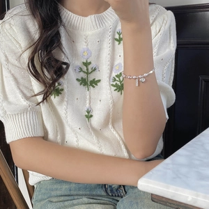 Élégant bracelet en argent 925 avec perles et cœur, porté par un mannequin dans un décor décontracté
