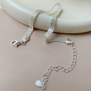 Détail macro du bracelet tissé en argent sterling S925 avec fermoir mousqueton réglable