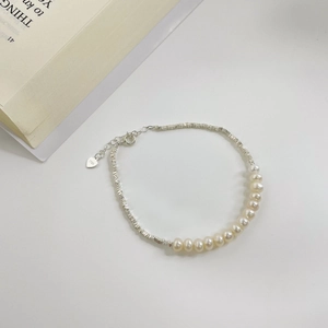 Close-up of S925 sterling silver beads and natural freshwater pearls on a delicate bracelet