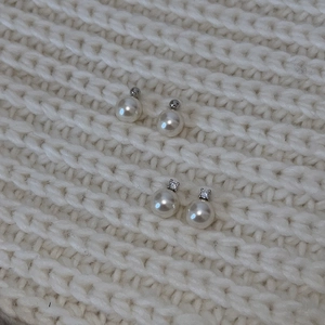 Detailed macro of 925 silver faux pearl earrings with crystal and metal accents