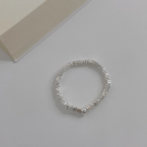 Detail of s925 silver beaded ring with irregular metallic pieces and a single round pearl
