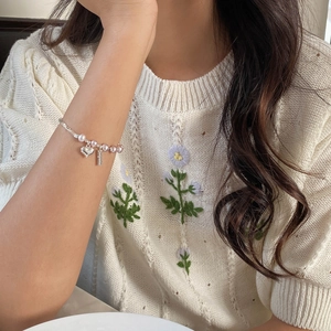 Détail du bracelet en argent S925 avec perles roses et pendentif cœur poli brillant
