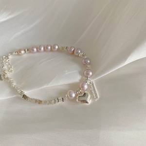 Détail d'un bracelet en argent S925 avec perles lavande et pendentif en cœur