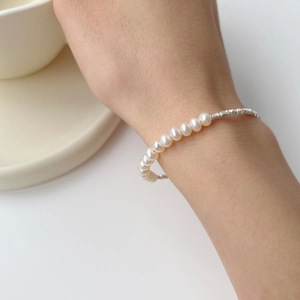 Detail of 925 sterling silver beads and natural freshwater pearl bracelet on wrist