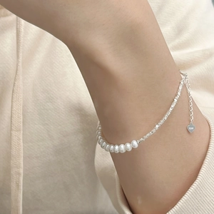 Close-up of 925 silver beads and white freshwater pearls on a delicate chain bracelet