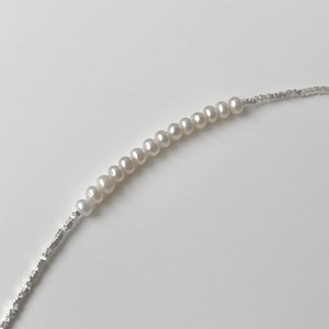 Detail of 925 silver faceted beads and natural freshwater pearls on a minimalist bracelet