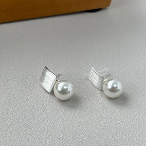 Detail of S925 silver geometric drop earring with brushed metal and white pearl