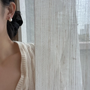 Elegant pearl stud earring with silver setting worn by a woman for a classic graceful look