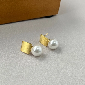 Detail of vintage French square pearl earrings with brushed gold finish and S925 silver studs