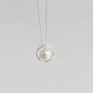 Detail showing irregular hollow S925 silver pendant with a round white freshwater pearl