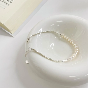 Minimalist S925 sterling silver crushed silver and white pearl bracelet in a ceramic bowl