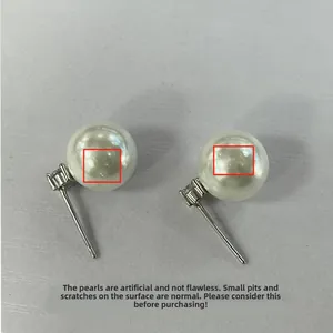 Detailed view of white shell pearls with natural surface textures on silver stud earrings