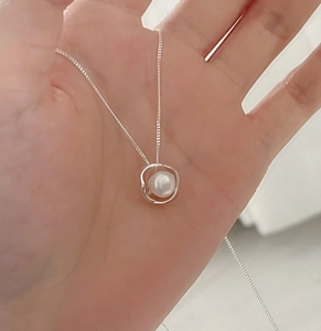 Close-up of minimalist 925 silver necklace with hollow irregular freshwater pearl pendant