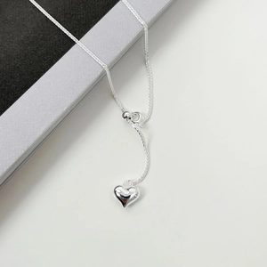 Elegant 925 sterling silver heart necklace with adjustable chain on minimalist pedestal